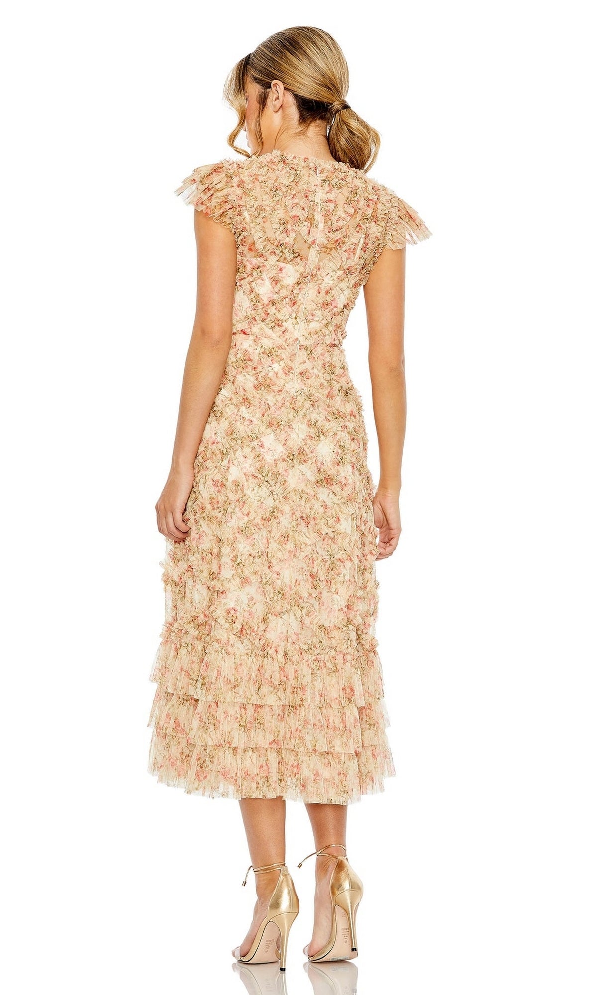 A woman stands with her back to the camera in the Mac Duggal 8060 Cap-Sleeve Wedding Guest Dress, featuring a floral print, ruffled layers, and cap sleeves, styled with gold high-heeled sandals.